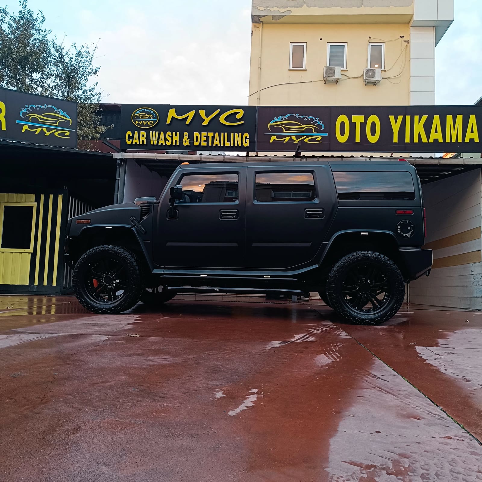 MYC tabelası önünde detaylı temizlik sonrası mat siyah Hummer H2